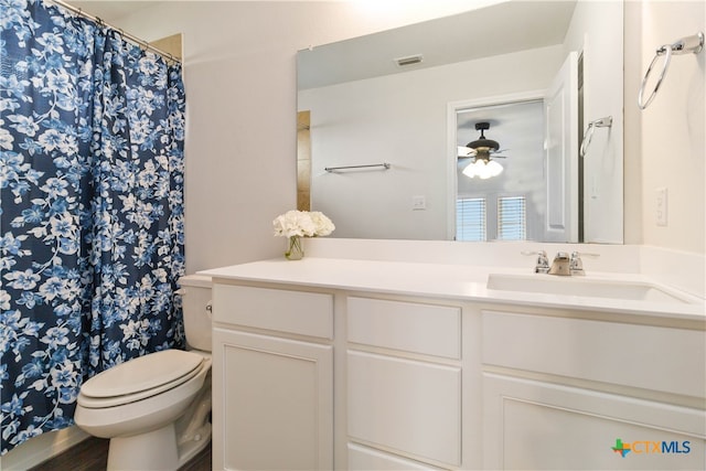 bathroom with toilet, vanity, hardwood / wood-style flooring, and ceiling fan