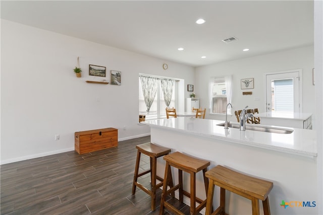 kitchen featuring dark hardwood / wood-style flooring, sink, and a kitchen bar