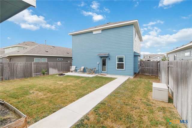 rear view of property with a yard and a patio area