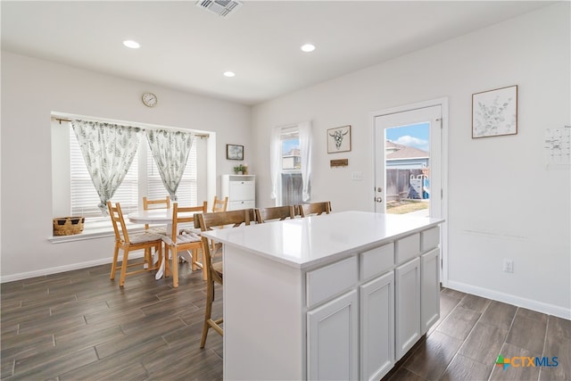 kitchen with dark hardwood / wood-style flooring, a breakfast bar area, and a kitchen island