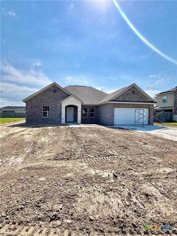 view of front of house featuring brick siding, driveway, and a garage