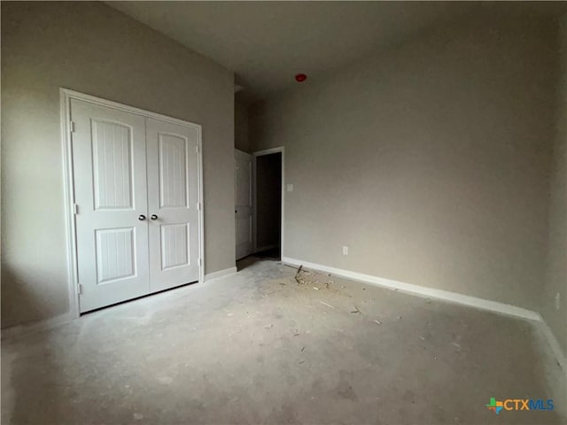 unfurnished bedroom with a closet and baseboards