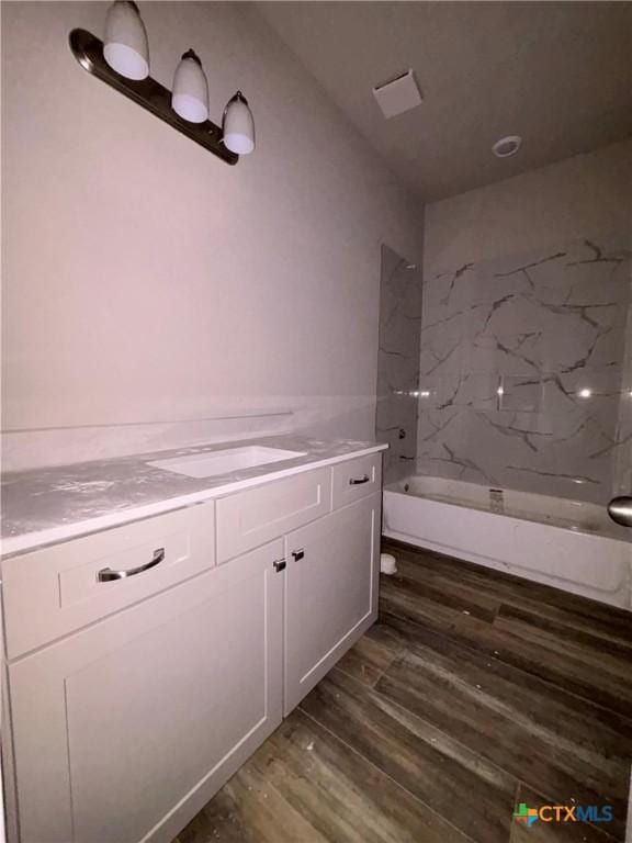 bathroom with vanity, bathtub / shower combination, toilet, and wood finished floors