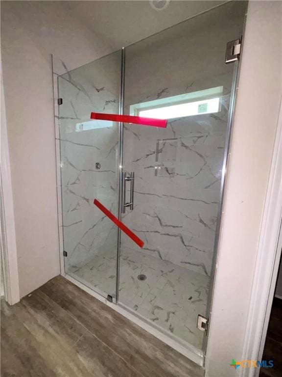 full bathroom with wood finished floors and a marble finish shower