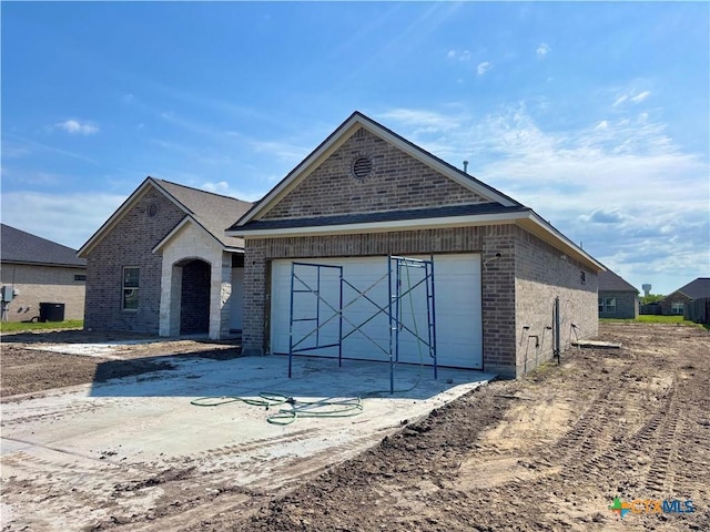 view of front facade featuring brick siding, driveway, and an attached garage
