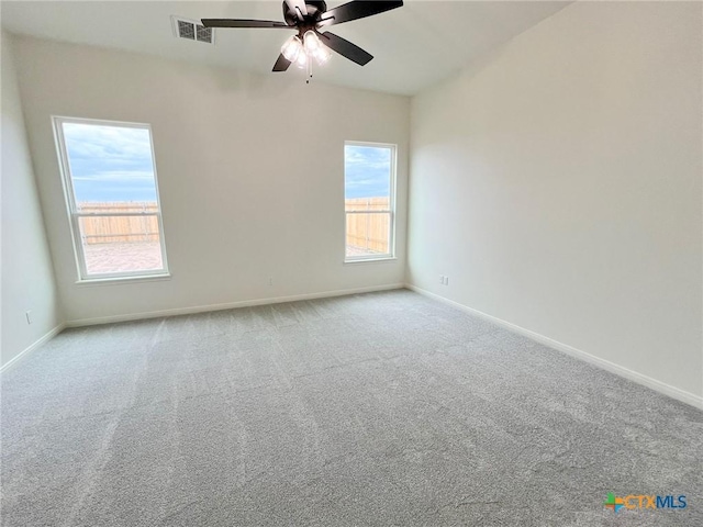 carpeted spare room featuring ceiling fan