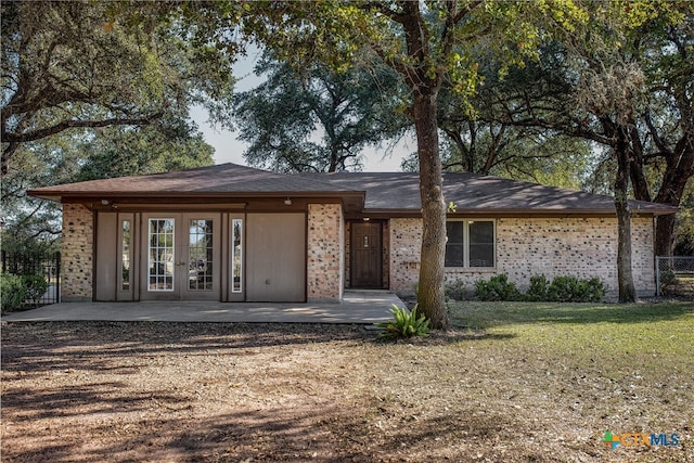 view of front of home with a front lawn, a patio, and french doors