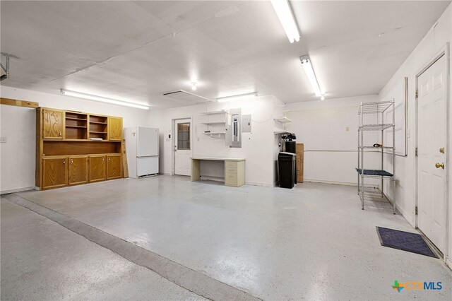 garage featuring electric panel and freestanding refrigerator