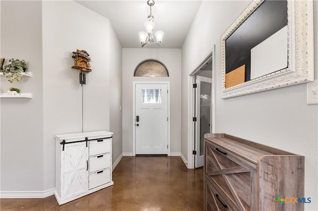 entrance foyer with a notable chandelier, baseboards, and finished concrete floors