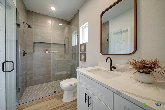 bathroom featuring vanity, toilet, and an enclosed shower