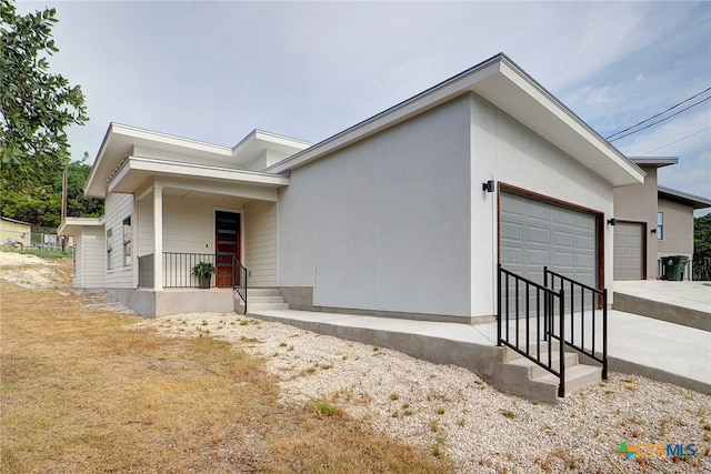 view of front of home with driveway, an attached garage, and stucco siding