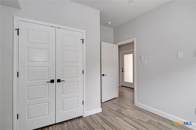 unfurnished bedroom with a closet and light hardwood / wood-style flooring