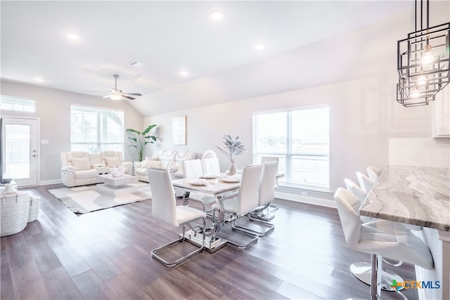 dining room featuring dark wood-type flooring, vaulted ceiling, and ceiling fan