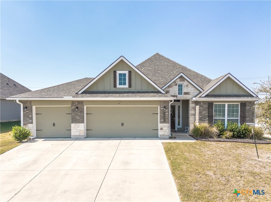 craftsman house with a garage and a front lawn