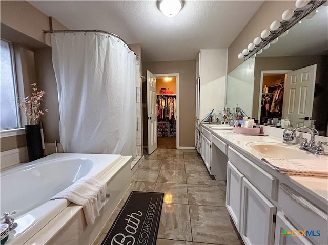 bathroom featuring vanity, a washtub, and a textured ceiling