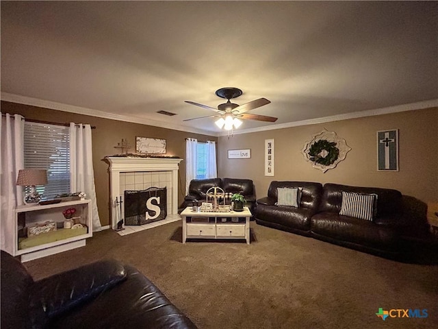 carpeted living room with crown molding, a tile fireplace, and ceiling fan