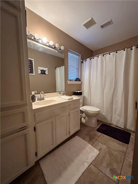 bathroom featuring vanity, tile patterned floors, and toilet