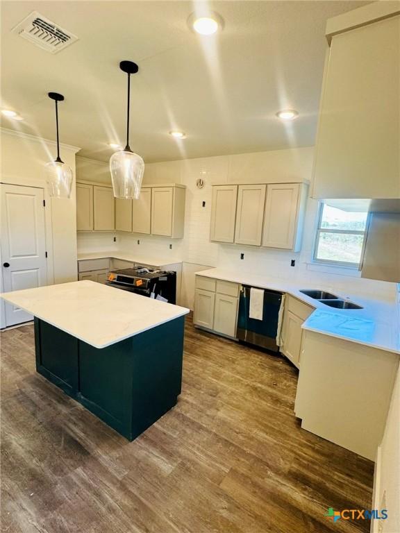 kitchen with a kitchen island, dark hardwood / wood-style floors, decorative light fixtures, black dishwasher, and sink