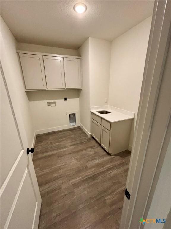 laundry area with cabinets, a textured ceiling, dark hardwood / wood-style floors, hookup for a washing machine, and hookup for an electric dryer