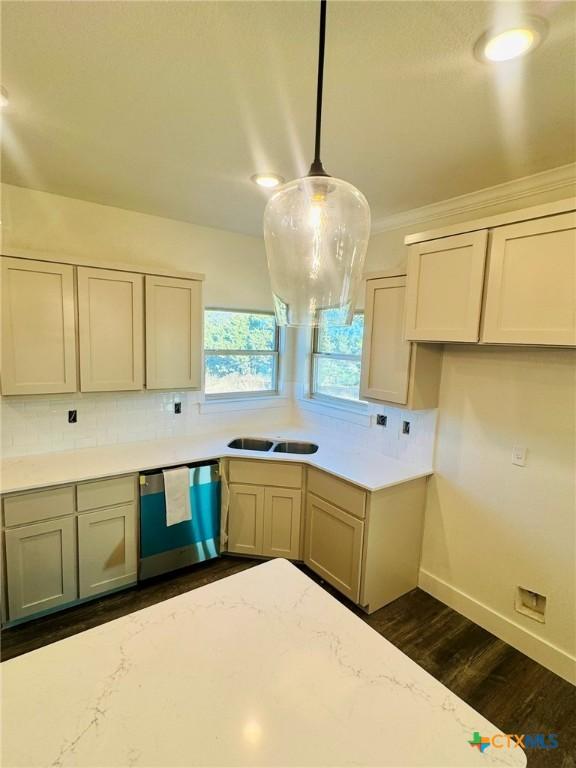 kitchen with pendant lighting, sink, dishwasher, light stone countertops, and dark hardwood / wood-style flooring