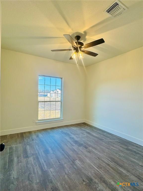 empty room featuring ceiling fan and dark hardwood / wood-style flooring