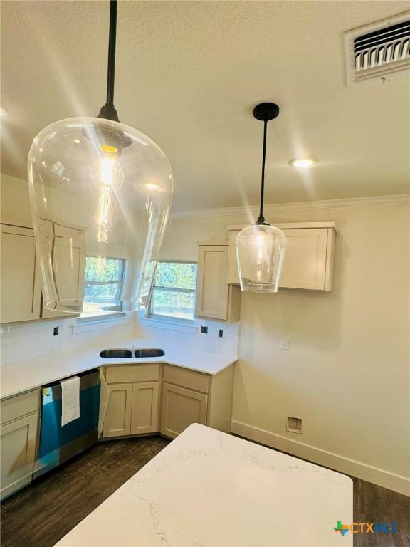 kitchen with dark wood-type flooring, crown molding, decorative light fixtures, dishwasher, and decorative backsplash