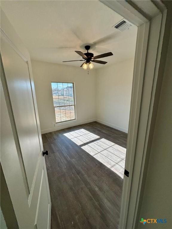 empty room featuring ceiling fan and dark hardwood / wood-style flooring