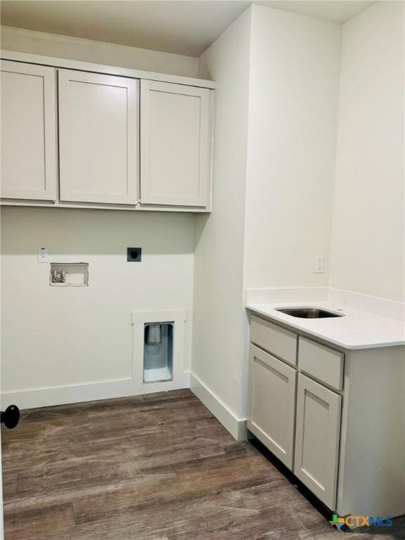 washroom featuring sink, cabinets, dark hardwood / wood-style floors, hookup for a washing machine, and hookup for an electric dryer