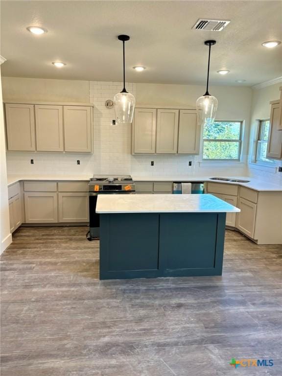 kitchen featuring gray cabinets, pendant lighting, stainless steel stove, and light hardwood / wood-style flooring