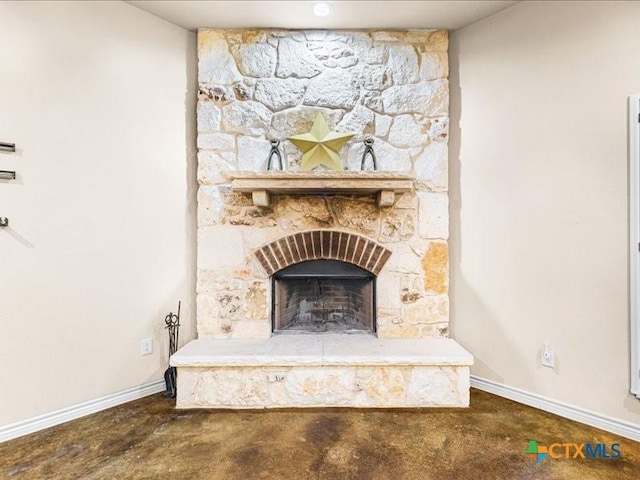 interior details with baseboards, concrete floors, and a fireplace