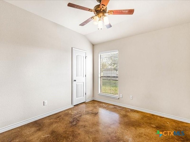 unfurnished room featuring baseboards, concrete floors, vaulted ceiling, and a ceiling fan