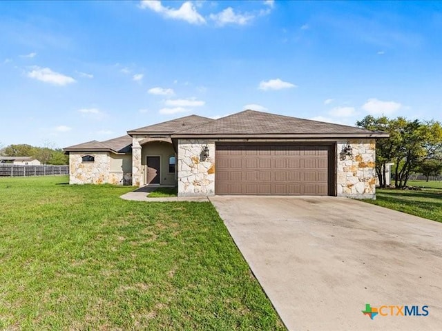 view of front facade featuring driveway, a front yard, stone siding, and a garage