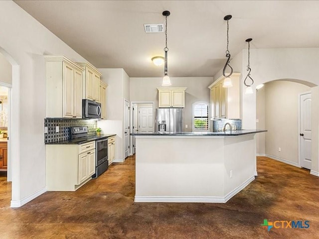 kitchen with cream cabinetry, dark countertops, arched walkways, visible vents, and appliances with stainless steel finishes