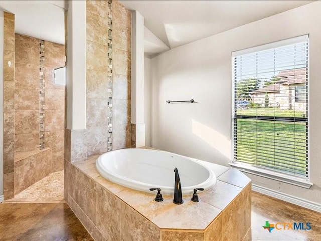 bathroom with baseboards, a tile shower, lofted ceiling, and a garden tub