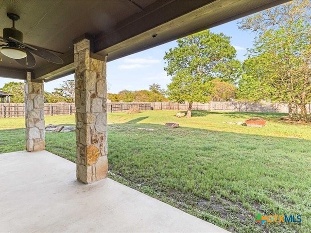 view of yard with a fenced backyard, a ceiling fan, and a patio area