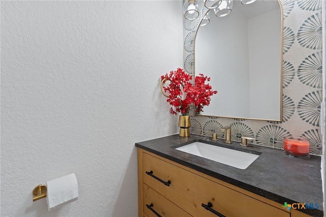 2534 Duval Dr, New Braunfels, TX 78130 - bathroom with vanity, decorative backsplash, a textured wall, and a chandelier