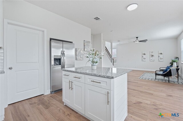 2534 Duval Dr, New Braunfels, TX 78130 - kitchen with stainless steel refrigerator with ice dispenser, light wood-type flooring, white cabinetry, and ceiling fan