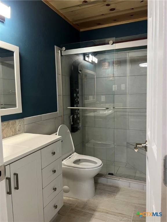 bathroom featuring toilet, a shower with shower door, wooden ceiling, tile walls, and vanity