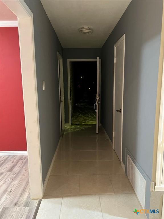 hall featuring light tile patterned floors