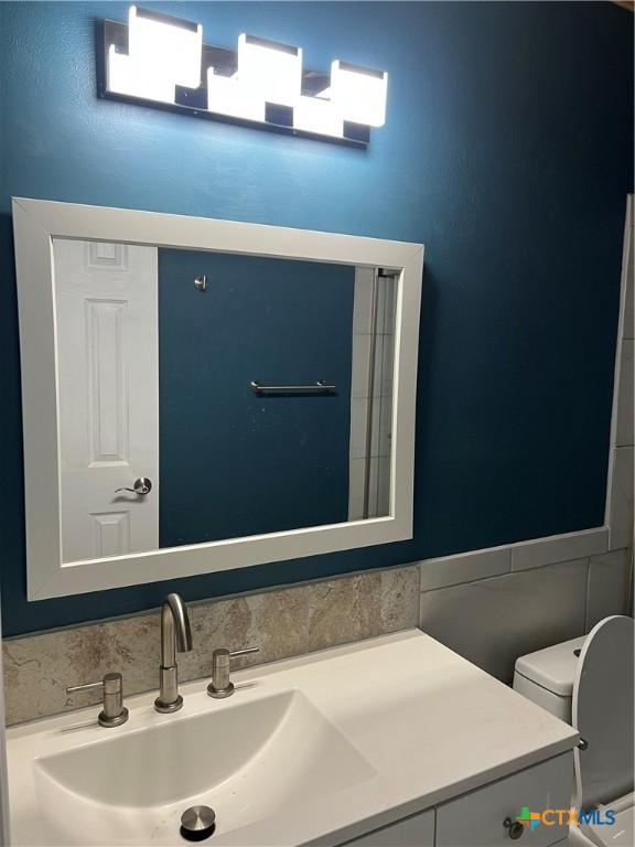 bathroom featuring toilet and vanity