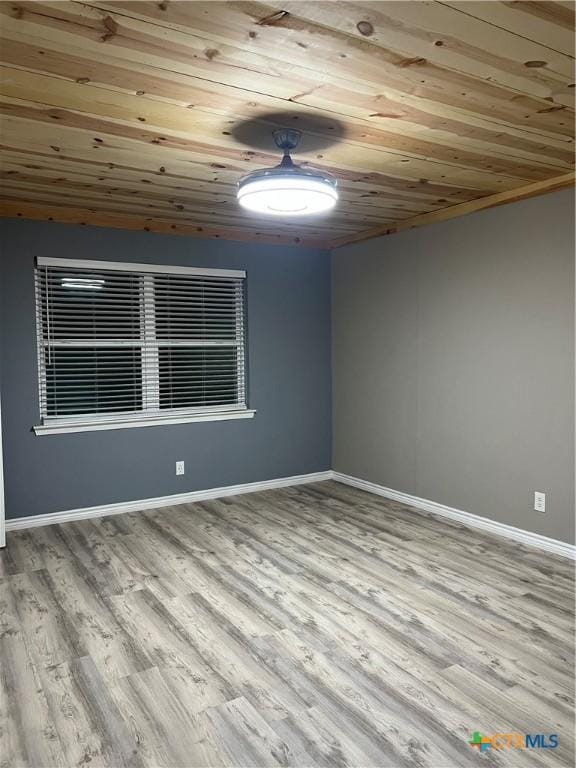 empty room with light wood-type flooring and wood ceiling