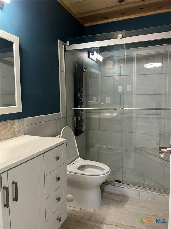 bathroom with toilet, tile walls, walk in shower, and vanity