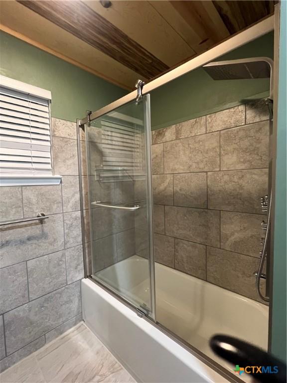 bathroom featuring shower / bath combination with glass door