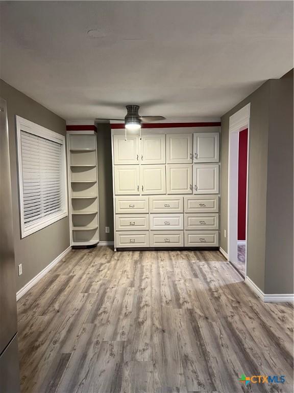 unfurnished bedroom with ceiling fan and hardwood / wood-style floors