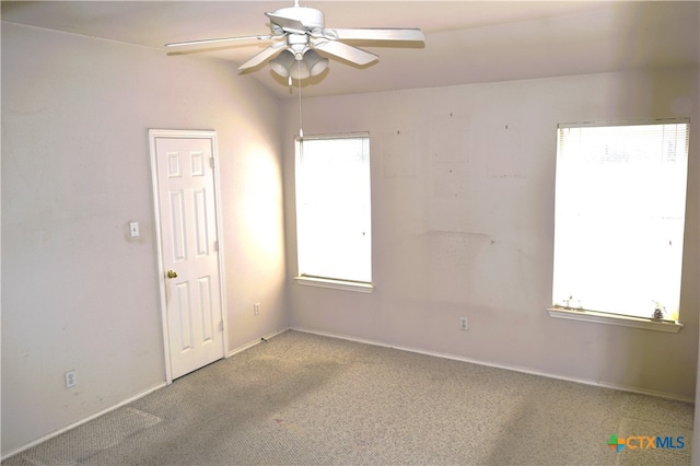 unfurnished room with a healthy amount of sunlight, light colored carpet, and ceiling fan