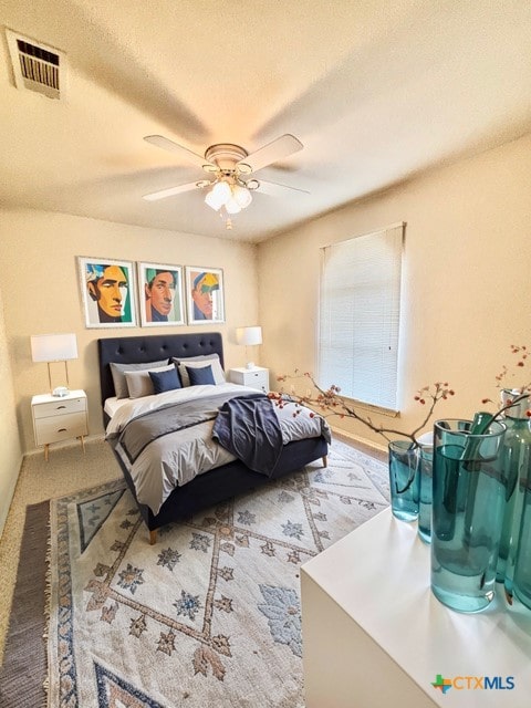 carpeted bedroom with ceiling fan and a textured ceiling