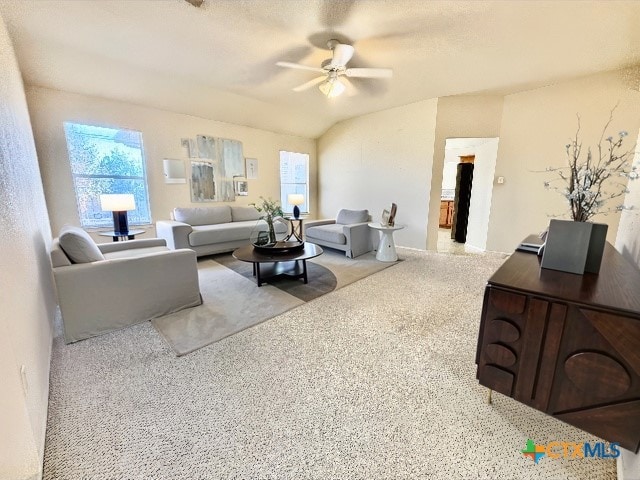 living room with vaulted ceiling, a wealth of natural light, a textured ceiling, and ceiling fan