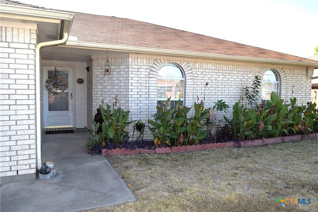 view of exterior entry featuring a yard