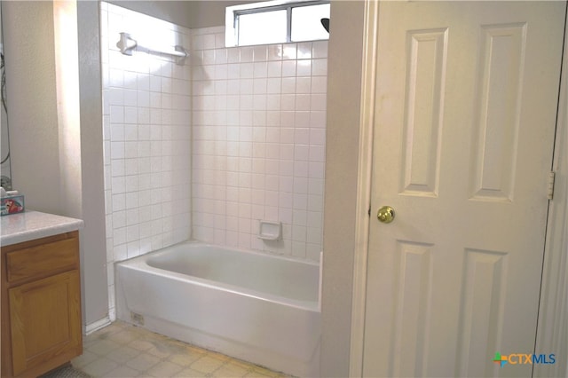 bathroom with tiled shower / bath and vanity