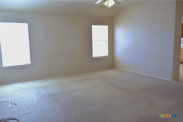 carpeted spare room with vaulted ceiling and ceiling fan